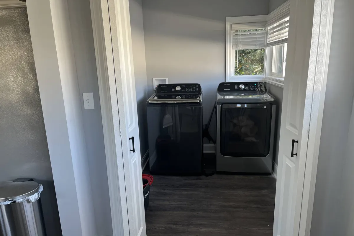 A laundry area featuring a washer and dryer next to a window. The space is bright and practical, highlighting the convenience of having laundry facilities within the home.